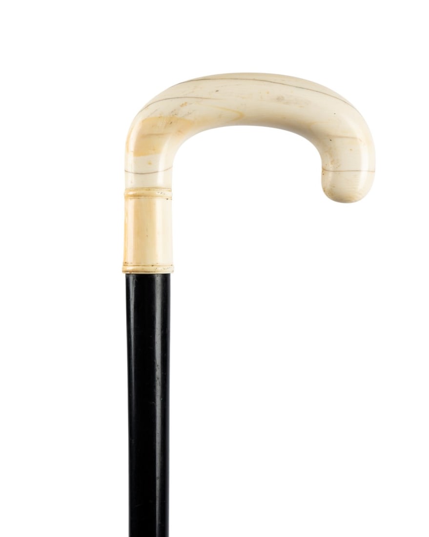 19TH C. ENGLISH CARVED CROOK HANDLE CANE: English, circa 1870. Walking cane with plain but finely carved crook handle with carved collar at the base, with ebony shaft terminating in a ferrule that matches the handle. Approximate