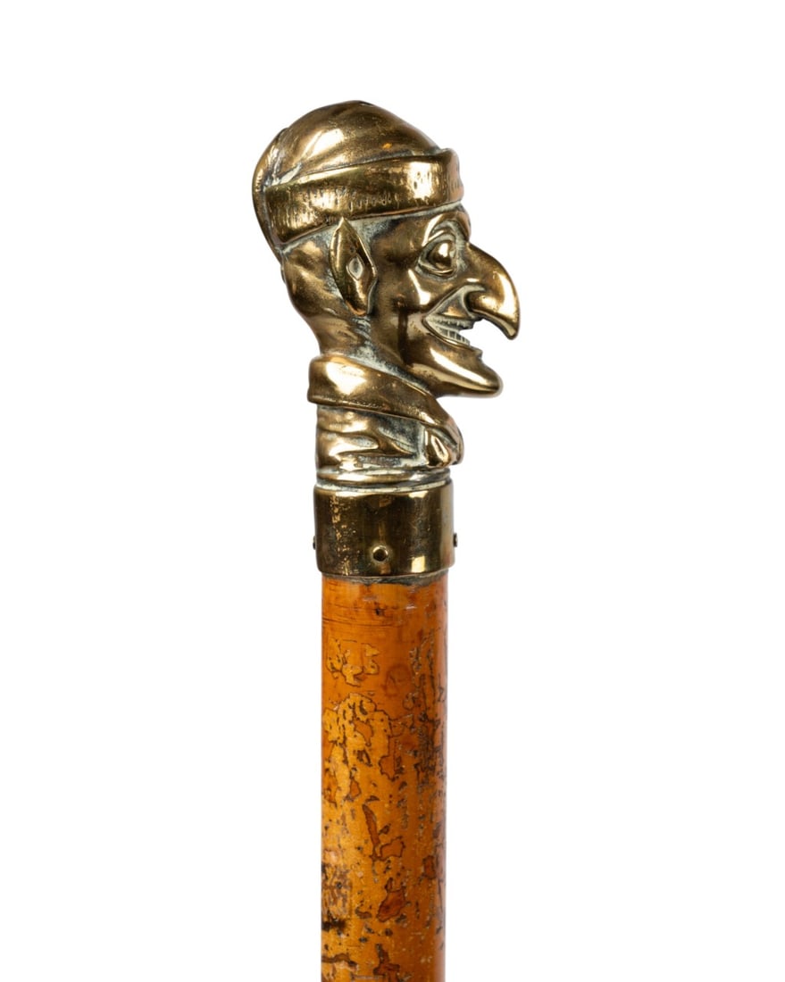 19TH C. ENGLISH MR. PUNCH BRASS HANDLE CANE: English, circa 1890. Walking cane with brass bust of Mr. Punch handle, with Malacca shaft, and brass ferrule. Approximate measurements: handle: 3.25"; length: 36.75"