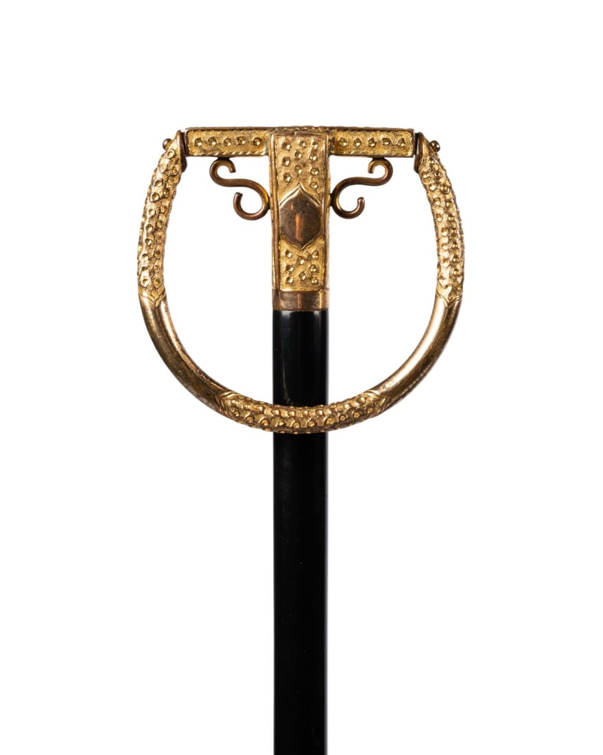 ENGLISH ORNATE WRIST CANE, C. 1880: English, circa 1880. Ornate Victorian wrist walking cane with gilt metal loop handle, connected to ebonized hardwood shaft, with light horn ferrule. Approximate measurements: handle: 4.25" ; length: