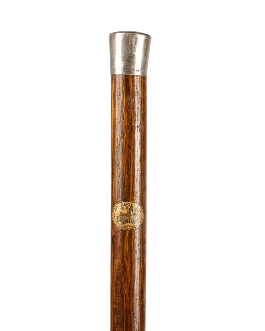 INDEPENDENCE HALL RELIC CANE W/ SILVER HANDLE: American, 1876. Relic walking cane with sterling silver knob handle, shaft made from oak salvaged from Independence Hall in Philadelphia, label below the handle indicating creation for the 1876 Centen