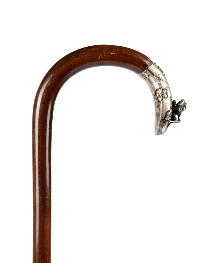 VENETIAN SILVER CROOK LION HANDLE CANE, C. 1880: Italian, circa 1880. Walking cane with silver crook handle decorated with florals, vines, and winged lion at top, silver limited to end of crook, with fruitwood shaft terminating in metal ferrule. 