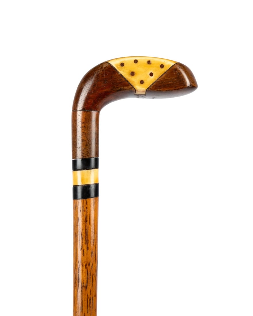 19TH C. SCOTTISH GOLF CLUB WALKING CANE: Scottish, circa 1890. Walking cane with carved wood handle shaped as golf club, inlaid with bone, supported by bone collar, with thin oak shaft terminating in metal ferrule. Approximate