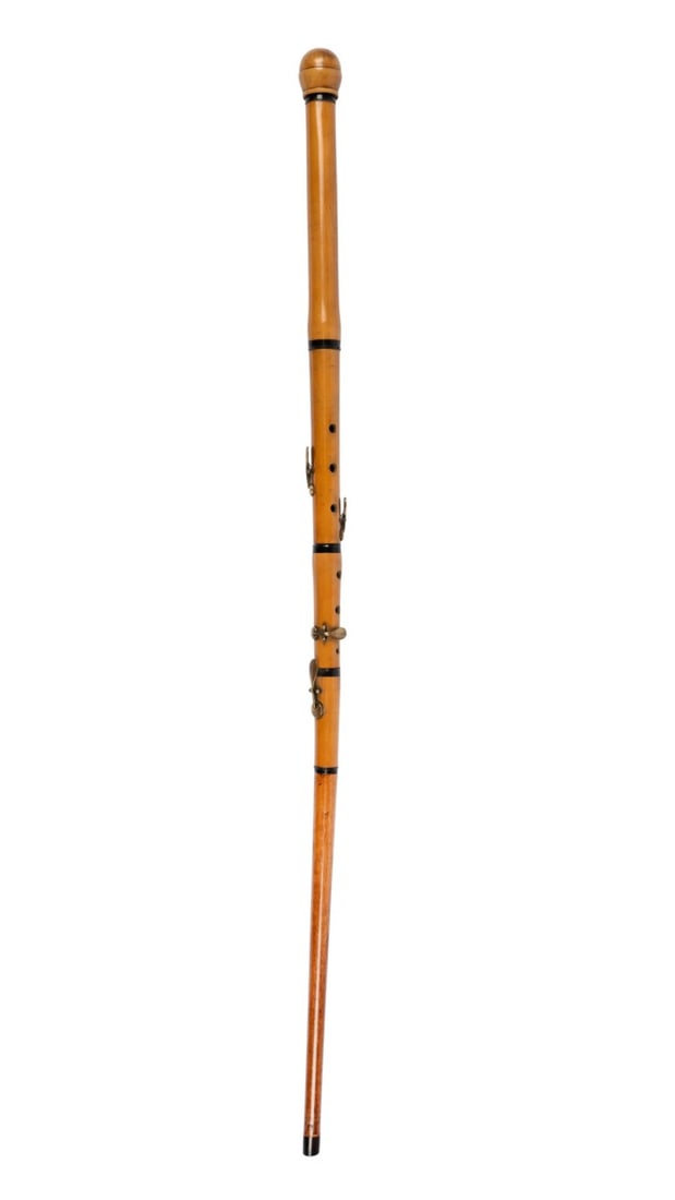 ENGLISH FLUTE MUSICAL CANE, C. 1880: English, circa 1880. Gadget walking cane made as a flute with carved burl wood knob handle and wooden stopper supported by black disk, bamboo shaft with six holes and four brass fittings, terminating