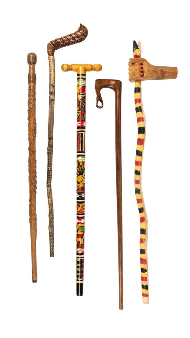 FIVE CARVED FOLK ART CANES: 20th century. Five assorted hand-carved folk art walking canes, including a snake cane with hand handle, a souvenir cane from Switzerland, a polychrome painted wood cane from South America, a carved w