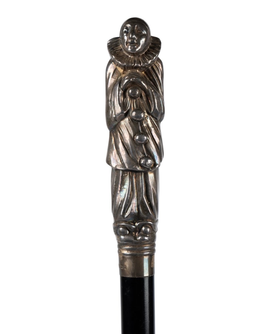 ENGLISH PIERROT CLOWN WALKING CANE, C. 1905: English, circa 1905. Walking cane with silver handle modeled as Pierrot in typical attire, collar marked, with ebonized wood shaft terminating in metal ferrule. Approximate measurements: handle: 6.25"
