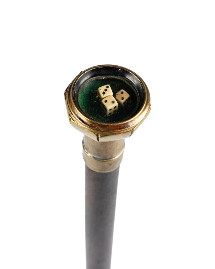 19TH C. ENGLISH GAMBLER'S WALKING CANE: English, circa 1860. Gambler’s system walking cane with brass container handle topped with glass lid housing three tiny dice, stained hardwood shaft terminating in natural rubber ferrule; designed t