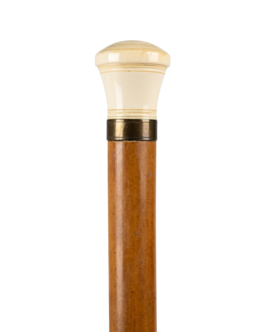 ENGLISH GAMBLER'S WALKING CANE, C. 1890: English, circa 1890. Gambler’s cane with carved knob handle, revealing a pair of carved dice and a spinning top when unscrewed, with brass collar, Malacca shaft, and horn ferrule. Approximate measur