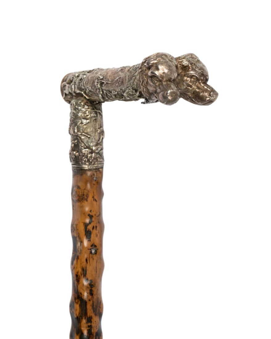 GERMAN HUNTER'S WALKING CANE, C. 1850: German, circa 1850. Hunter’s walking cane with silver handle ending in two-headed dog and hunting scenes in relief, illegible silver mark at base of dog’s head, screw below handle revealing compar