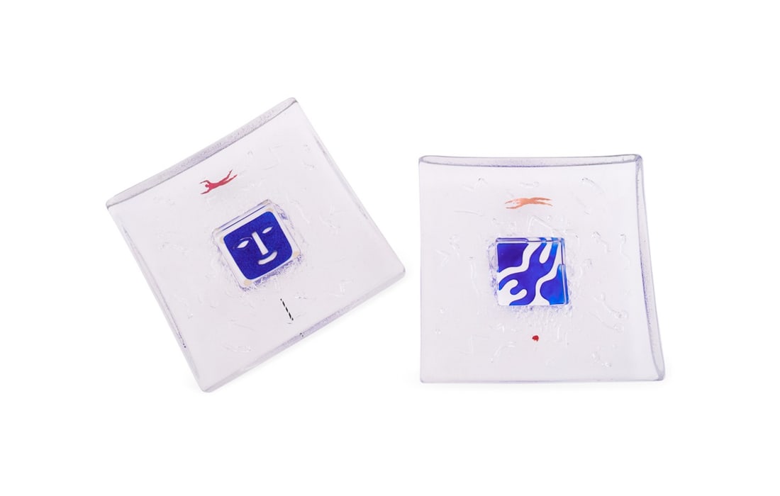 B. VALLIEN FOR KOSTA BODA, 2 DOMINO SERIES PLATES: Bertil Vallien (Swedish, born 1938) for Kosta Boda (Swedish, founded 1742). Set of two Domino series Modern studio glass figural plates or dishes (numbers 79365 and 79368), both appropriately marked.