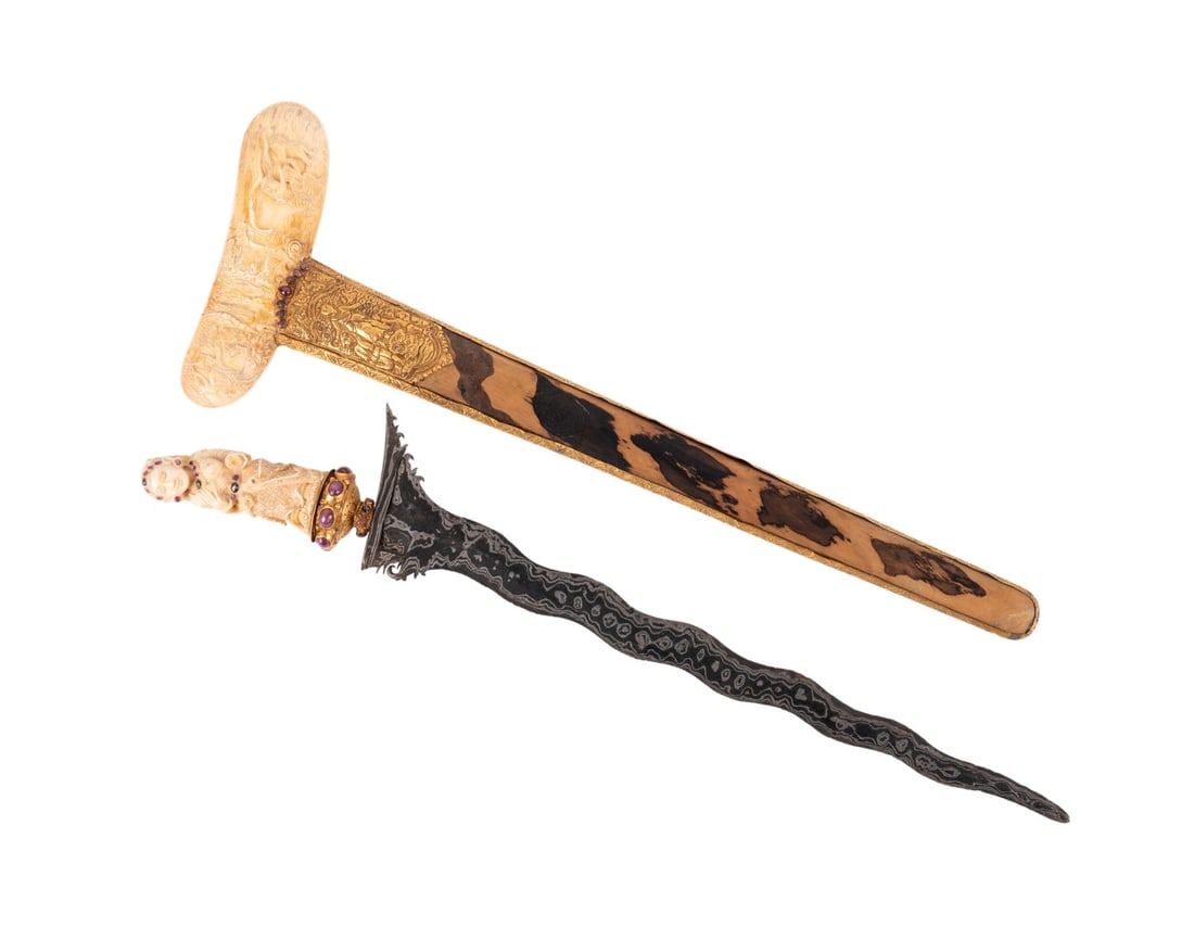 INDONESIAN KRIS, MYTHOLOGY CARVINGS, GOLD AND BONE: Southeast Asian. Indonesian Kris / Keris having a carved bone hilt depicting female figure, ruby and sapphire mounted selut and mendak, supported on a Hindu mythological scene carved bone wrangka, sim