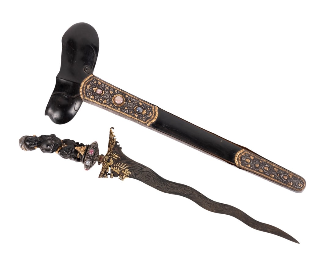 BALINESE EBONY KRIS, GODDESS SHASHTHI, JEWELS/GOLD: Southeast Asian. Balinese Kris / Keris, having a carved ebony goddess Shashthi handle, with a silver gilt head cover and gold accents; silver and sapphire cabochon mounted selut, glass stone mounted