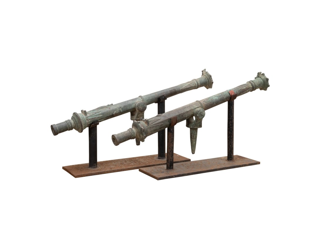 TWO LANTAKA BRONZE SWIVEL CANNONS, BORNEO: Indonesia, (Borneo) 18th /19th century. Two near pair bronze swivel Lantaka cannons, one depicting a crocodile motif atop the barrel, adjacent to the ignition hole. Accompanied by stands. Provenance: