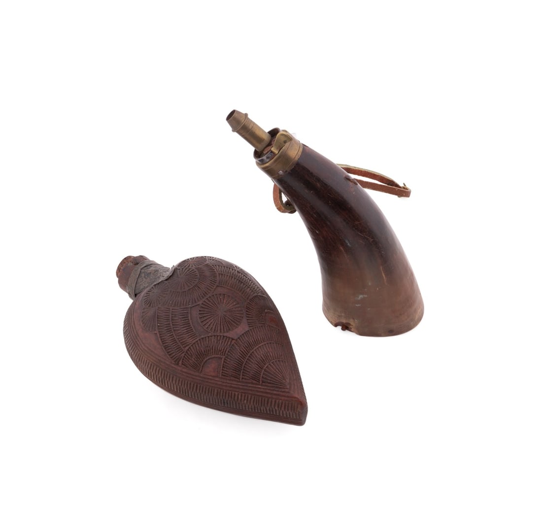 TWO POWDER FLASKS, ONE EUROPEAN ONE OTTOMAN: Two antique gunpowder flasks. One Turkish example carved of wood in a heart shape; the other a European powder horn fitted with a brass spout, apparently unsigned. Provenance: The Estate of Edward