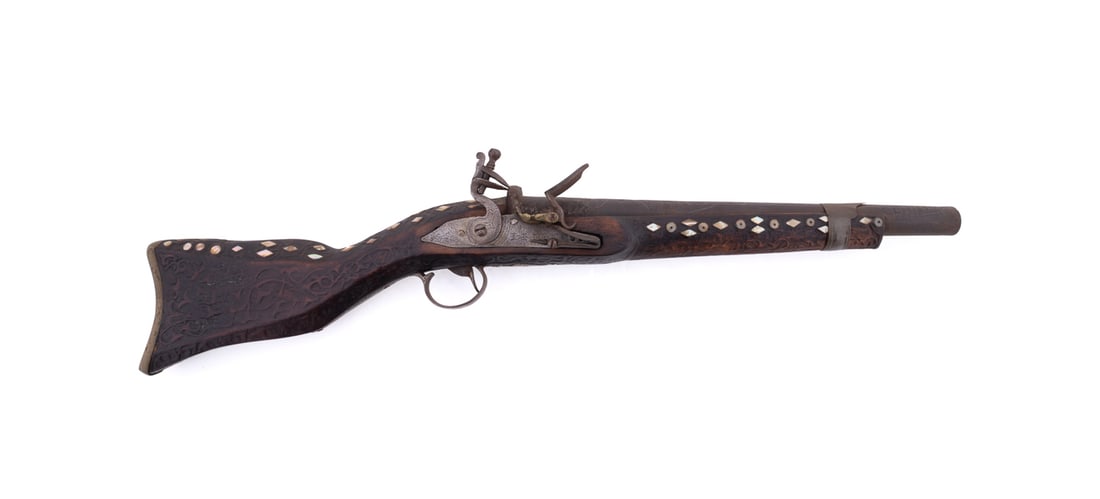 OTTOMAN MOP INLAY SHORT BARREL RIFLE: Ottoman / Turkish, late 19th / early 20th century. Heavy flintlock short barrel rifle, with a heavily carved stock; stock having inlaid mother-of-pearl and carved scrolling foliate motif, apparently