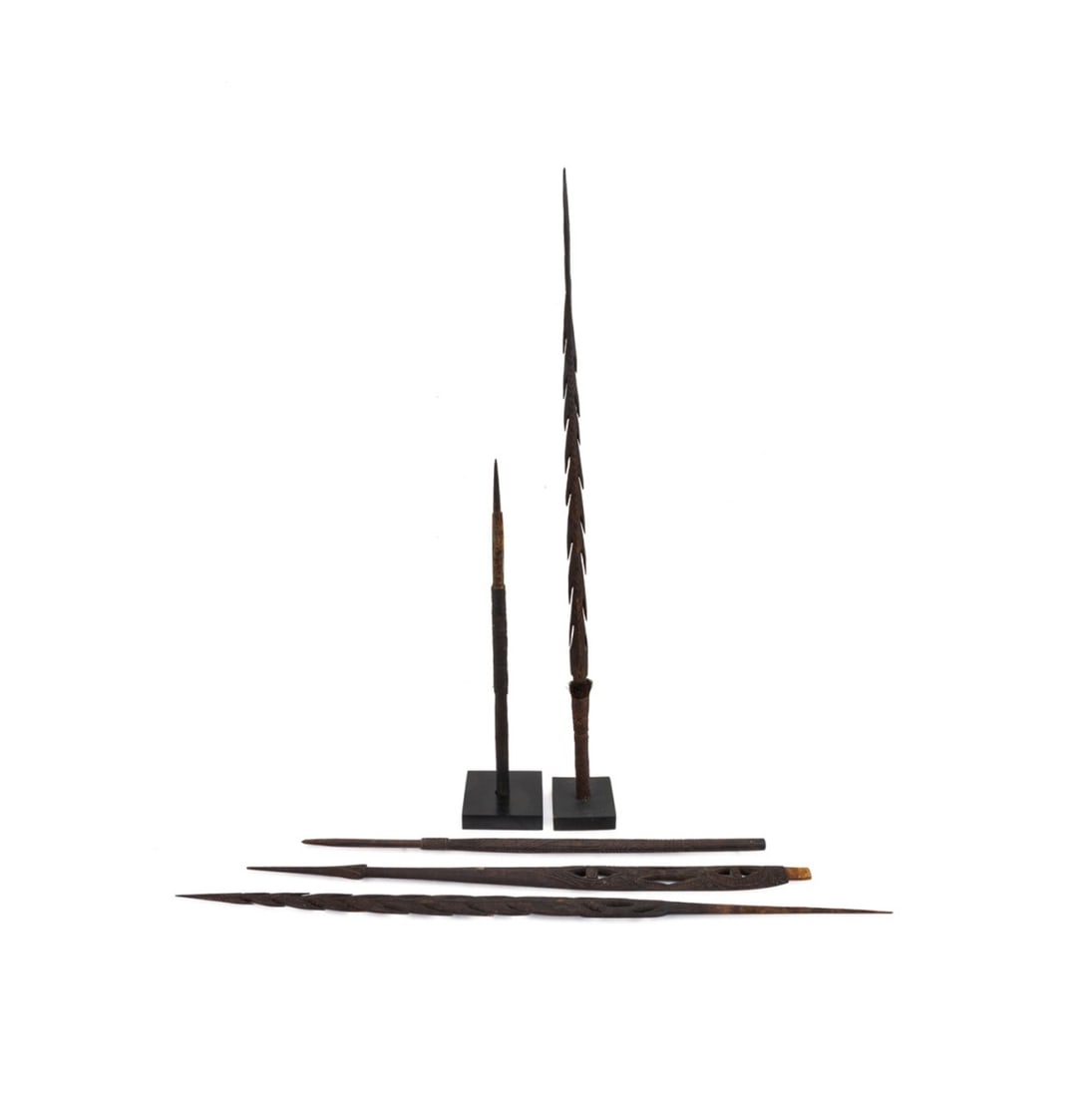 5 PAPUA NEW GUINEA SPEARS AND SPEAR TIPS: Five Papua New Guinea wooden spears and spear tips, likely for fishing, several with intricately carved patterns, and two accompanied by stands, apparently unmarked. Approximate dimensions: tallest h.