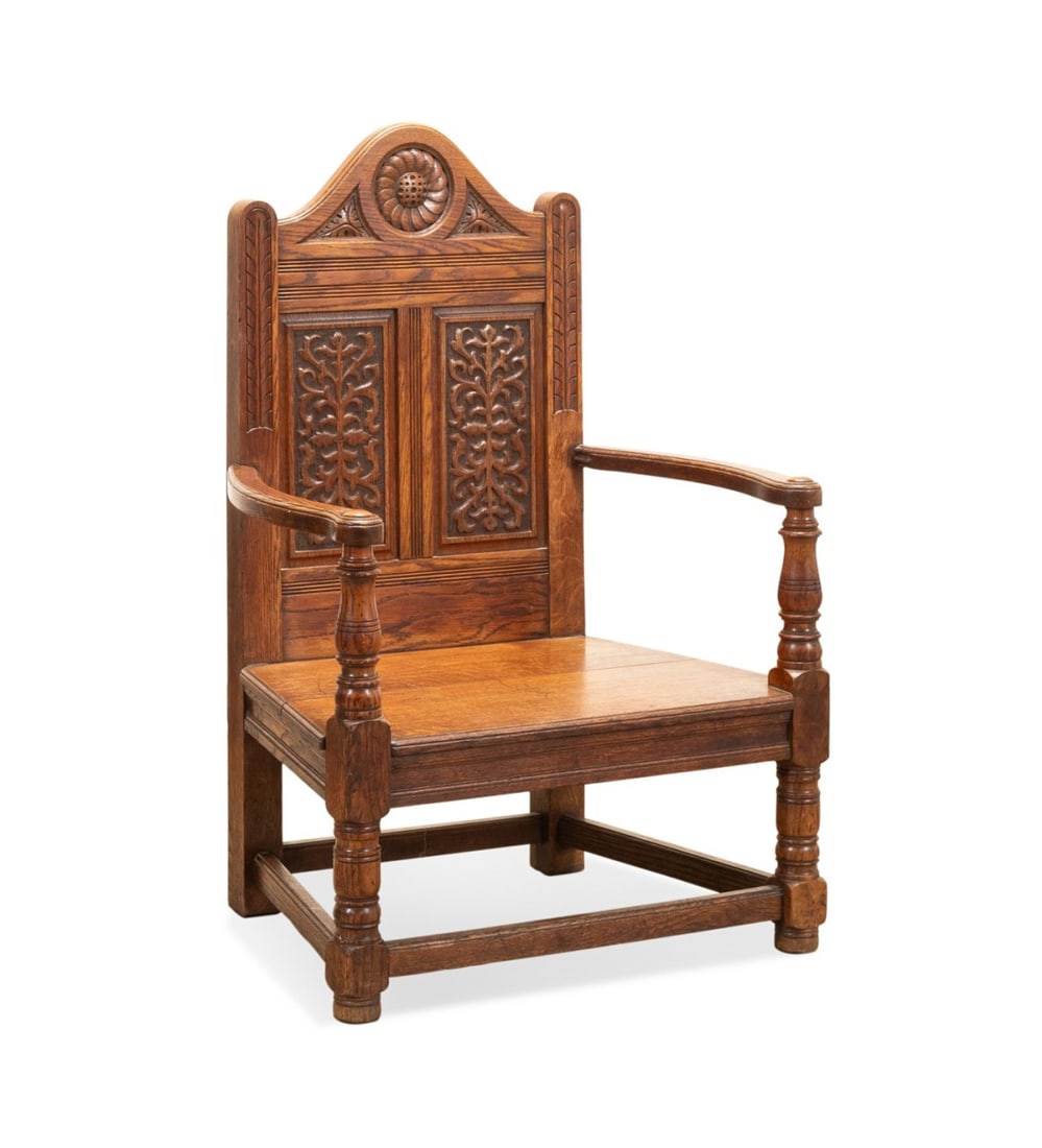 CHARLES I STYLE OAK WAINSCOT ARMCHAIR, C. 1900: English, circa 1900. Carved oak wainscot armchair in the Charles I taste, having foliate decoration, and rising on front onion feet. Approximate dimensions: h. 40", w. 26.75", d. 20"; seat h. 13".
