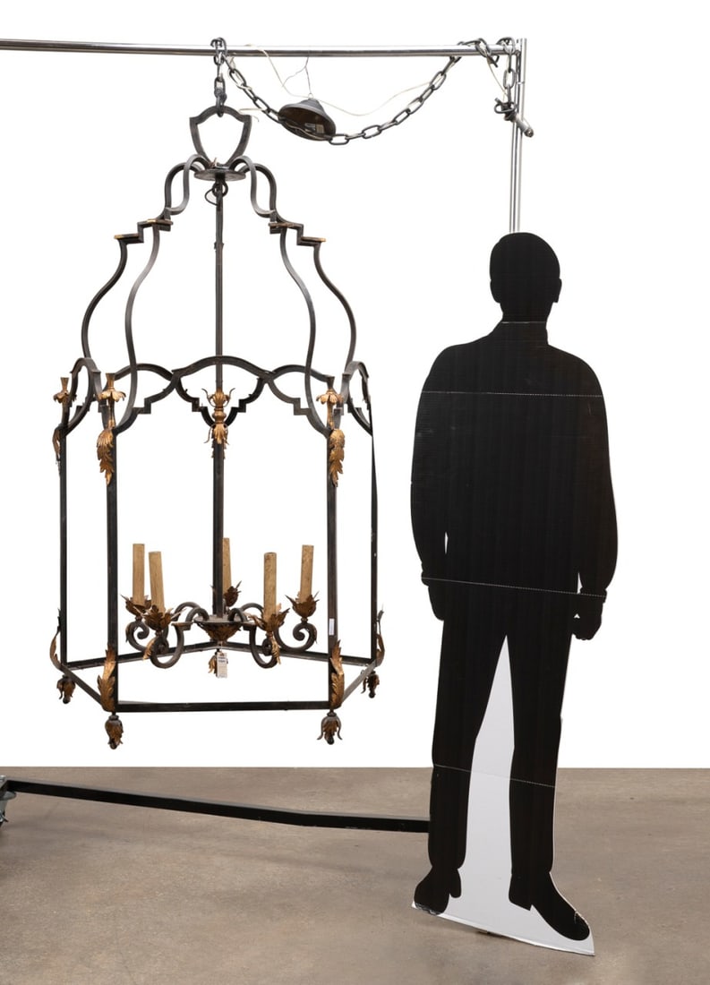 OVERSIZED IRON & PARCEL GILT ENTRANCE HALL LANTERN: Manner Paul Ferrante (American, founded 1957), late 20th century. Oversized wrought iron and parcel gilt entrance hall lantern in the Louis XV taste, having a pentagon-form shaped frame, acanthus leaf