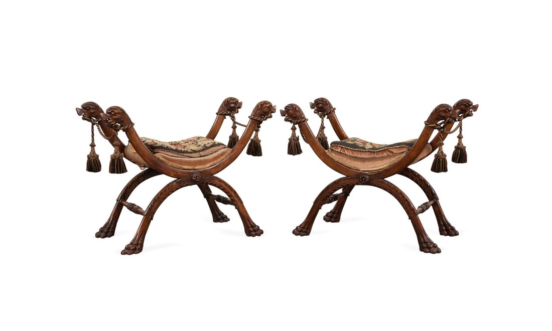 PAIR OF GRIFFIN HEAD CURULE BENCHES, C. 1880: European, circa 1880. Walnut curule stool or bench, each having griffin head hand rests, and rising on paw feet, both apparently unmarked. Provenance: Estate of Scott Hudgens and Jacqueline Casey Hudg