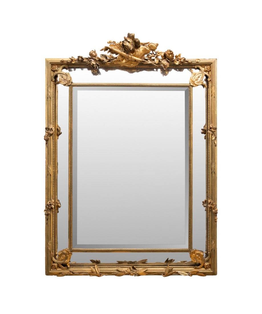 NAPOLEON III GILTWOOD & COMPOSITION MIRROR: French, 19th century. Napoleon III giltwood and composition cushion mirror having a floral crest and central beveled plate, apparently unmarked. Approximate dimensions: h. 54", w. 37.25", d. 5".