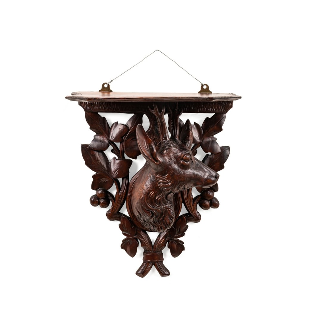 BLACK FOREST CARVED STAG'S HEAD WALL BRACKET: Continental, 19th / 20th century. Carved Black Forest wooden wall bracket, having a shaped shelf supported by a stag on a pierced foliate backplate, apparently unmarked. Provenance: Estate of Scott