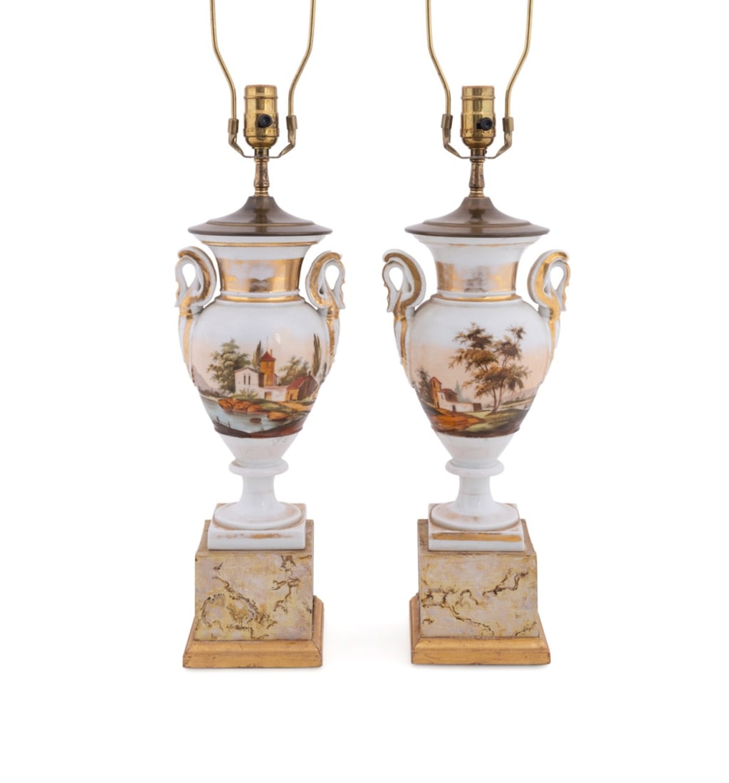 PAIR OF OLD PARIS PORCELAIN VASES MOUNTED AS LAMPS: French, 19th century. Pair of Old Paris porcelain urns, now mounted as lamps, each having a painted landscape scene, double eagle handles, and rising on a faux marble painted wooden base, with shades,
