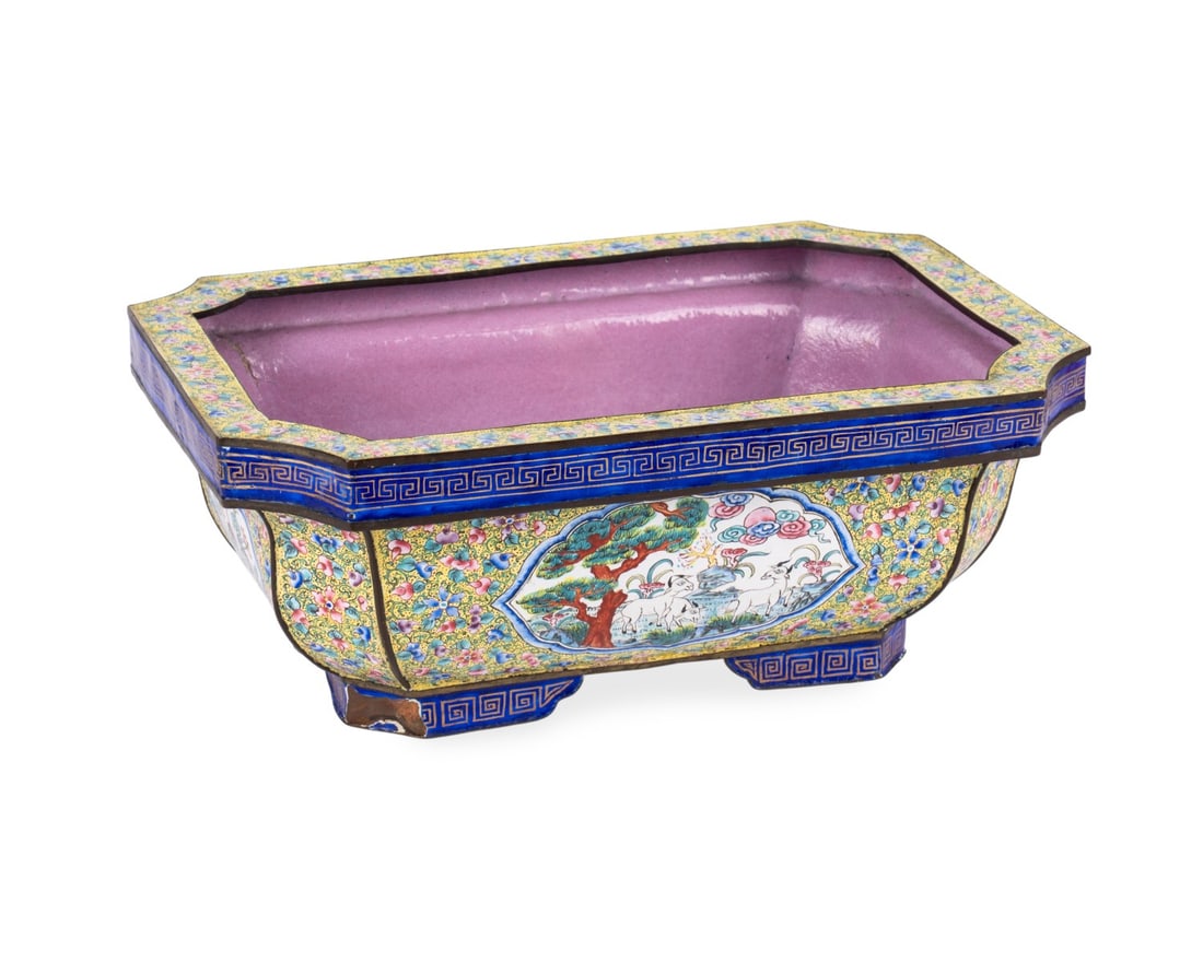 CHINESE CANTON ENAMEL JARDINIERE: Chinese, 19th century. Rectangular yellow enamel planter having reserved panels depicting grazing goats amongst a landscape, elaborate pink and blue millefleur pattern, lavender enamel interior and bl