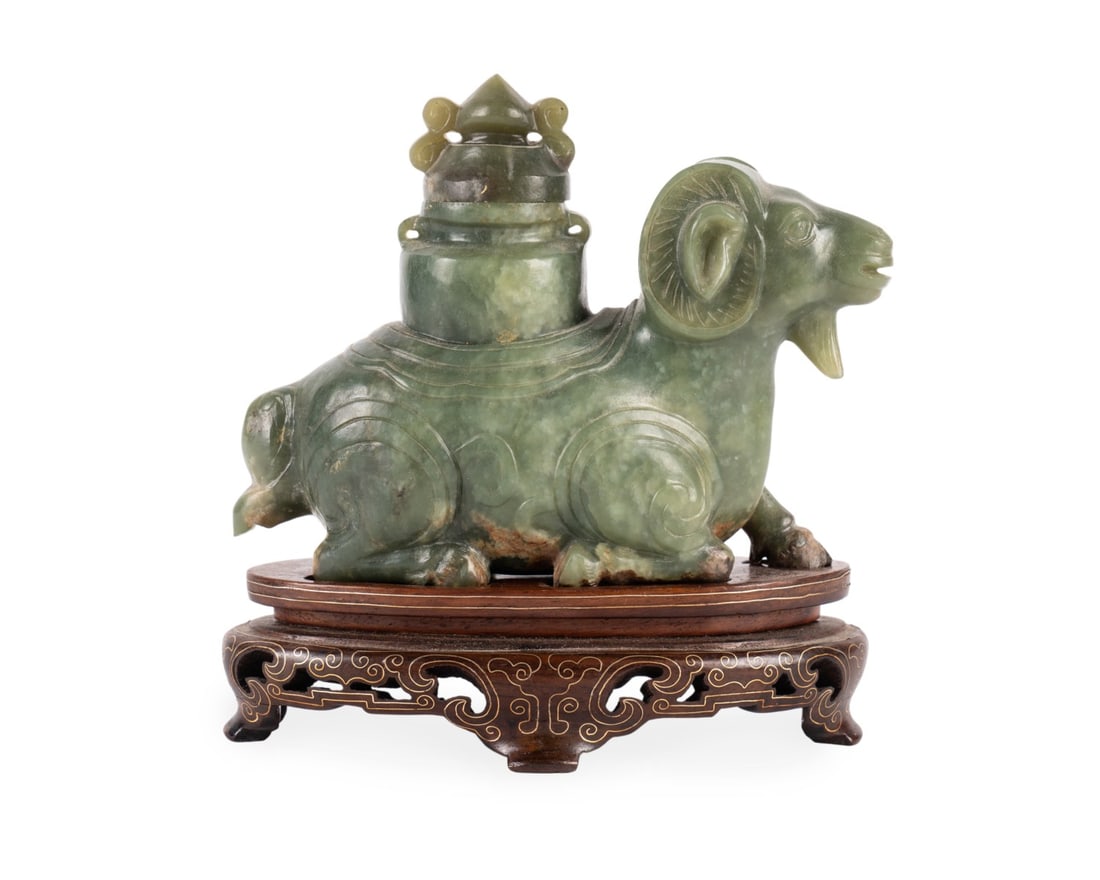 GREEN JADEITE RAM ON INLAID STAND: Asian, late 19th century. Carved green jade recumbent ram vessel with lid, and incised decorations, on a custom rosewood stand with brass inlay, apparently unmarked. Provenance: Private Collection of