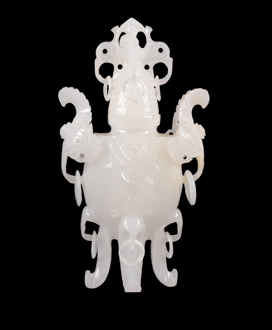 CHINESE WHITE JADEITE INCENSE BURNER: Chinese, 20th century. Covered urn shaped white jade incense burner, carved with traditional archaic symbols of dragon and elephant heads, movable ball within the finial lid, stylized dragon handles,