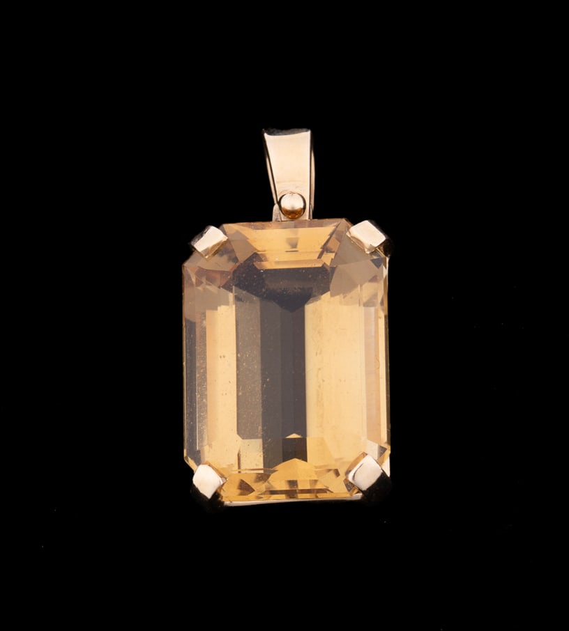 CITRINE & 14K YELLOW GOLD PENDANT: Citrine pendant featuring a rectangular step cut citrine weighing approximately 24.70 total carats, prong set in yellow gold. Tested as 14K gold. Approximate dimensions: l. 1.875"; total weight 10.18