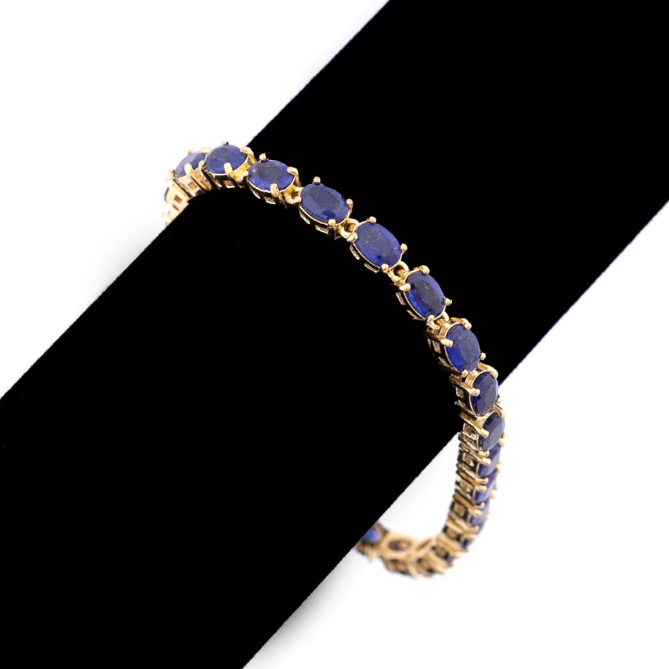 NATURAL BLUE SAPPHIRE VERMEIL BRACELET: Sapphire bracelet featuring (25) natural blue sapphires weighing approximately 22 total carats set in sterling silver / vermeil terminating in a box clasp. Marked 925 to clasp. Approximate dimensions:
