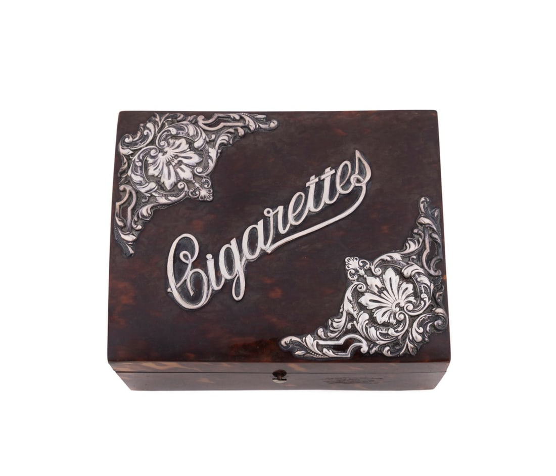ENGLISH SILVER MOUNTED SHELL 'CIGARETTES' BOX: English early 20th century. Art Deco silver mounted shell veneer cigarette box, having a hinged lid with scroll and acanthus motif silver mounted corners and wood lined interior, apparently unmarked.