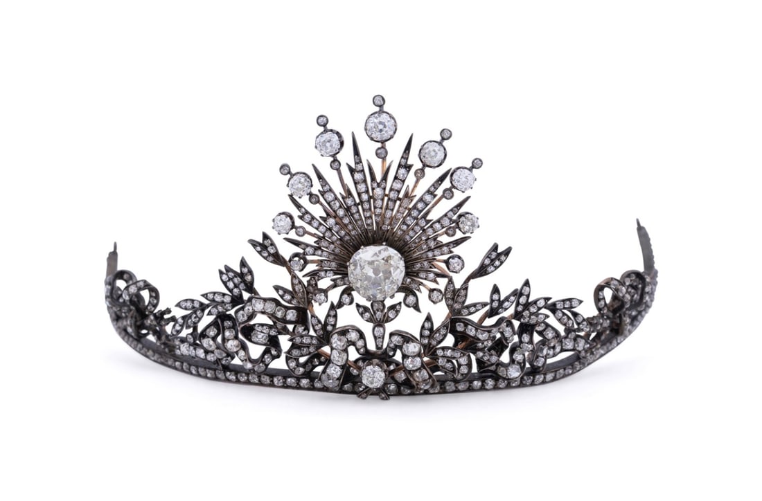 BELLE EPOQUE DIAMOND TIARA, 5.25CT CENTER: Likely Continental, late 19th to early 20th century. Belle Epoque era diamond tiara, having a scrolled diamond set ribbon-patterned frame with quiver and torch motif joined by a lover's knot, set in s