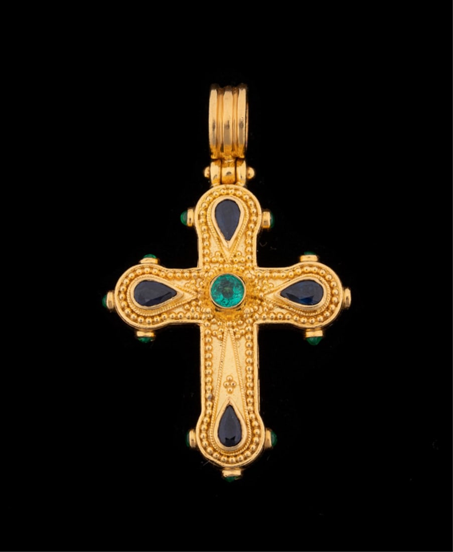 22K YELLOW GOLD CROSS PENDANT WITH GEMS: Cross pendant featuring (1) round green emerald and (4) pear cut dark blue sapphires weighing approximately 1.02 total carats, along with additional smaller green gemstones to sides, set in 22k stampe