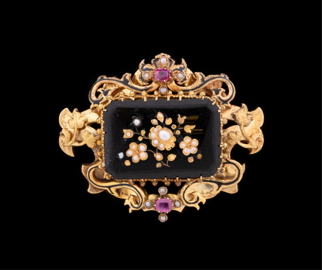 YELLOW GOLD BROOCH W/ GREEN GLASS, RUBIES, PEARLS: Cast 14k yellow gold brooch accented by (2) pinkish red rubies, seed pearls, and black enamel featuring a rectangular piece of dark green glass adorned with yellow gold and seed pearls to form a flora