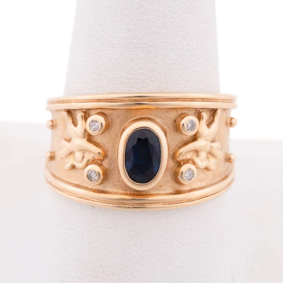 SAPPHIRE AND DIAMOND RING, 14K GOLD ETRUSCAN BAND: Sapphire and diamond ring with 14K yellow gold setting featuring an oval shape dark blue sapphire weighing approximately 0.45 total carats, and (4) round brilliant cut diamonds weighing approximately