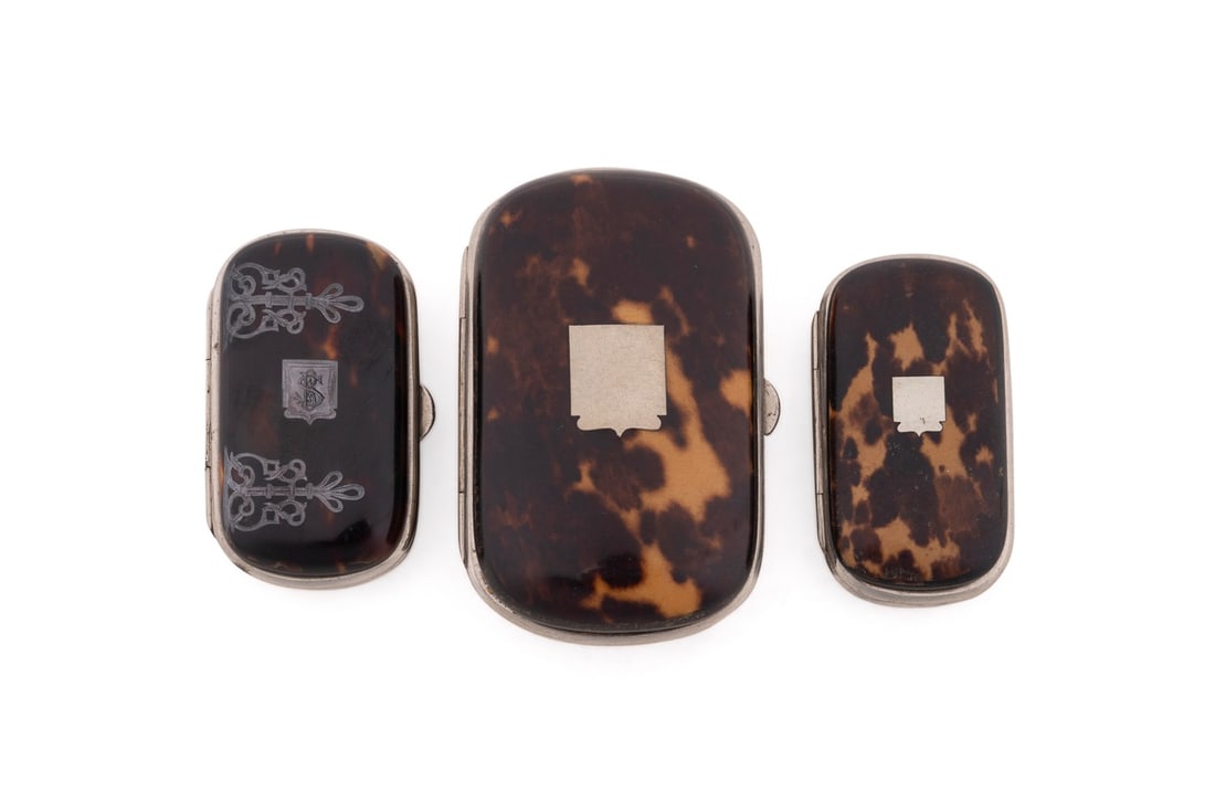 ENGLISH, THREE SILVER OVERLAY SHELL MATCH CASES: English, early 20th century. Group of three shell mounted and faux shell painted match cases, having decorative silver overlay and hinged lids, apparently unmarked.