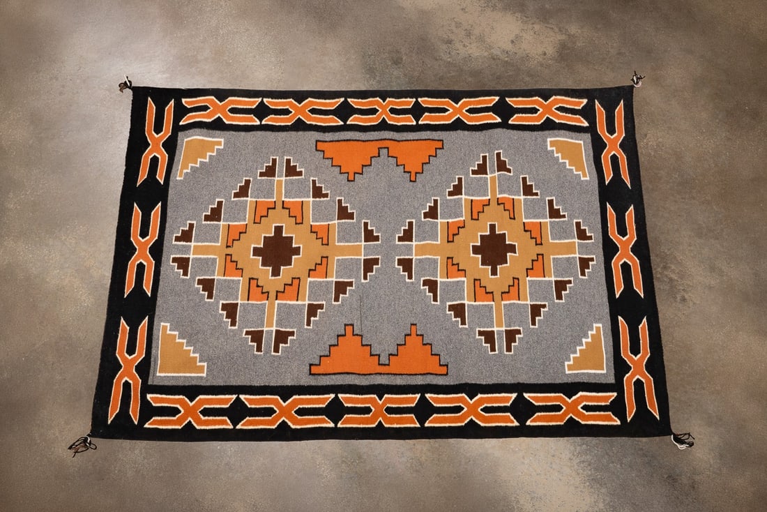 HANDWOVEN NAVAJO TEEC NOS POS RUG: Native American, late 20th century. Navajo Teec Nos Pos rug having a dark brown, orange, and ochre double-diamond medallion on a grey field with orange "X" motifs on black outer border, apparently uns