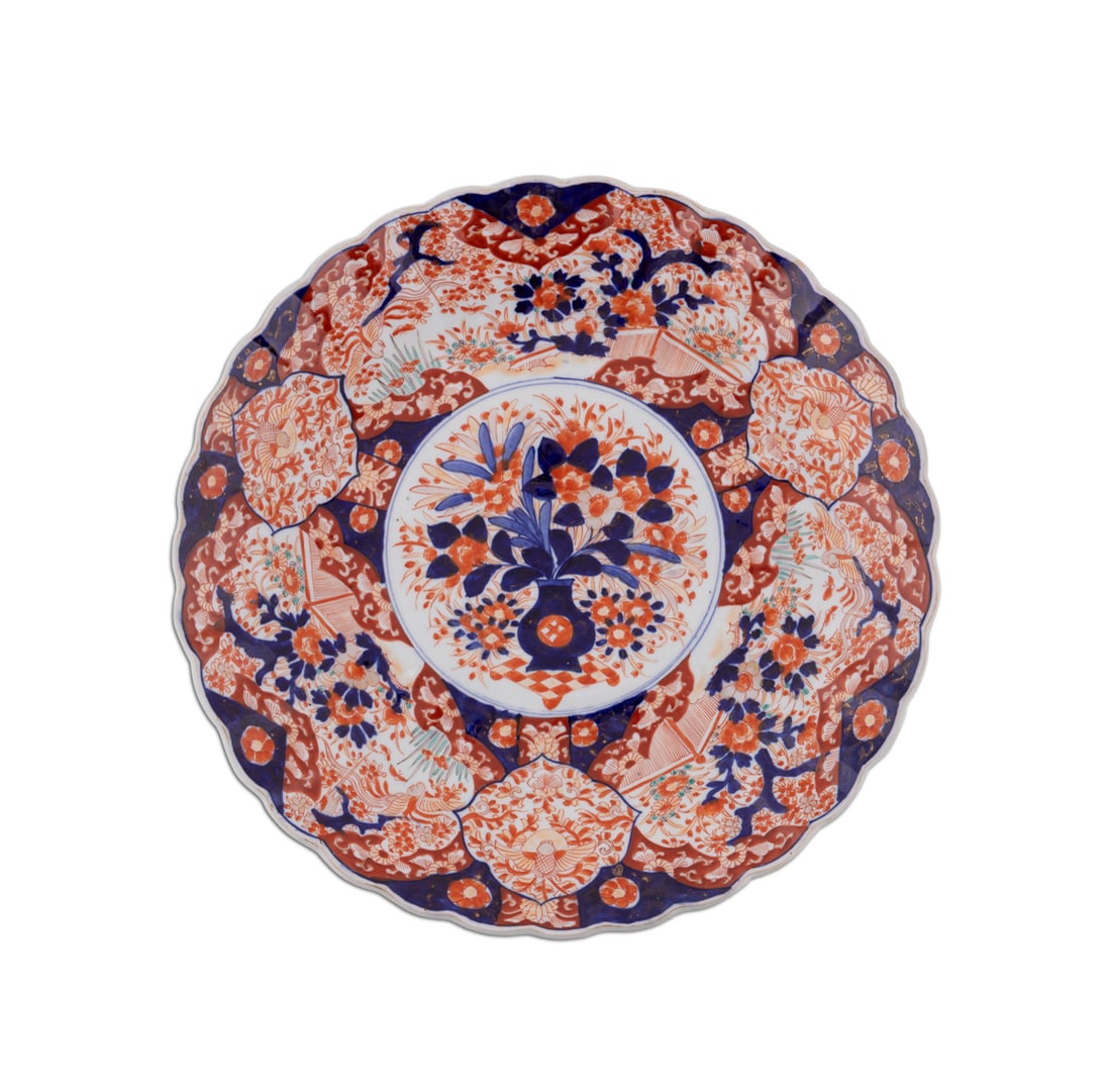 Japanese Large Imari Scallop Rim Charger: Large Imari Porcelain Scallop Rim Charger Japanese Having reserves decorated with florals encircling a flower filled urn, with blue and white decoration to the underside. Apparently unmarked. Flat: 2 