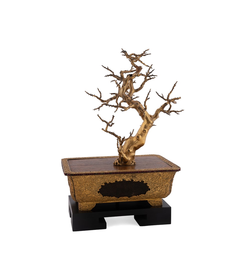 Japanese Gilt Bronze Bonsai in a Patterned Suiban: Gilt Bronze Bonsai in a Patterned Suiban Japanese Having a dormant bonsai, in a scrolled floral gilt bronze suiban or planter, with red glass gems in the rim, and fine inset geometric mesh panels, on 