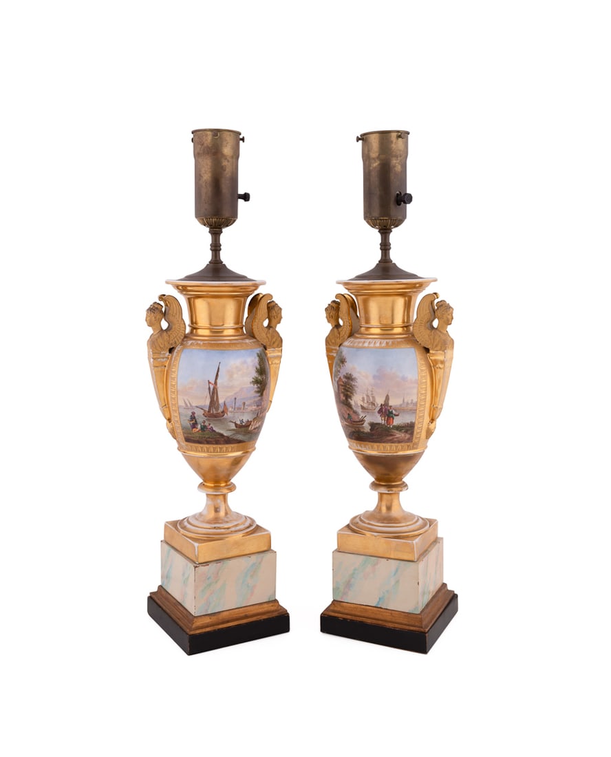 Pair of Old Paris Porcelain Urns Mounted as Lamps: Pair of Old Paris Porcelain Urns Mounted as Lamps 19th Century, French Each gilded urn having a single light, double winged female handles, and reserve with figural harbor scene, now on a faux marble 