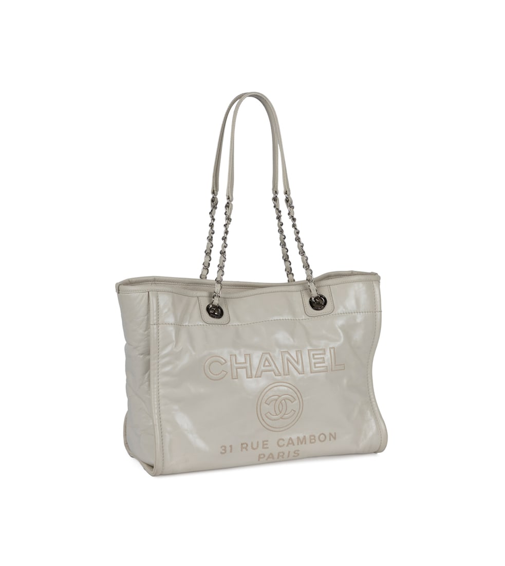 Chanel Glazed Calfskin Deauville Tote Off-White: Chanel (French, founded 1910), 2016 - 2017. With "Chanel / 31 Rue Cambon / Paris" and large CC logo embroidered to front, silver toned hardware, chain link and leather straps, exterior quilted