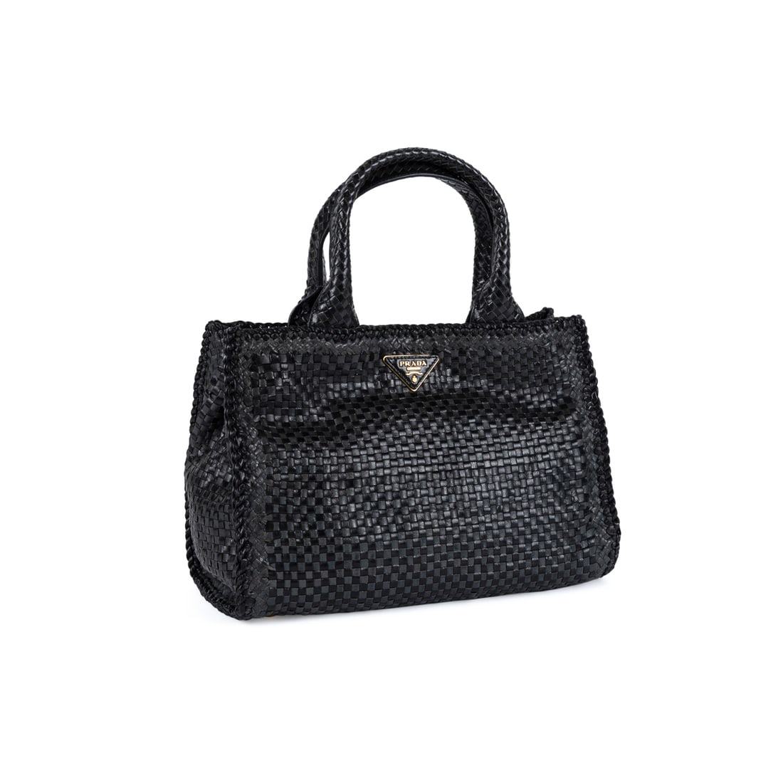 Prada Madras Convertible Handbag in Black Leather: Prada (Italian, founded 1913). Black woven leather Madras handbag with two top handles, removable crossbody strap, two tone greyish black and black weave, gold toned hardware, suede interior lining, a