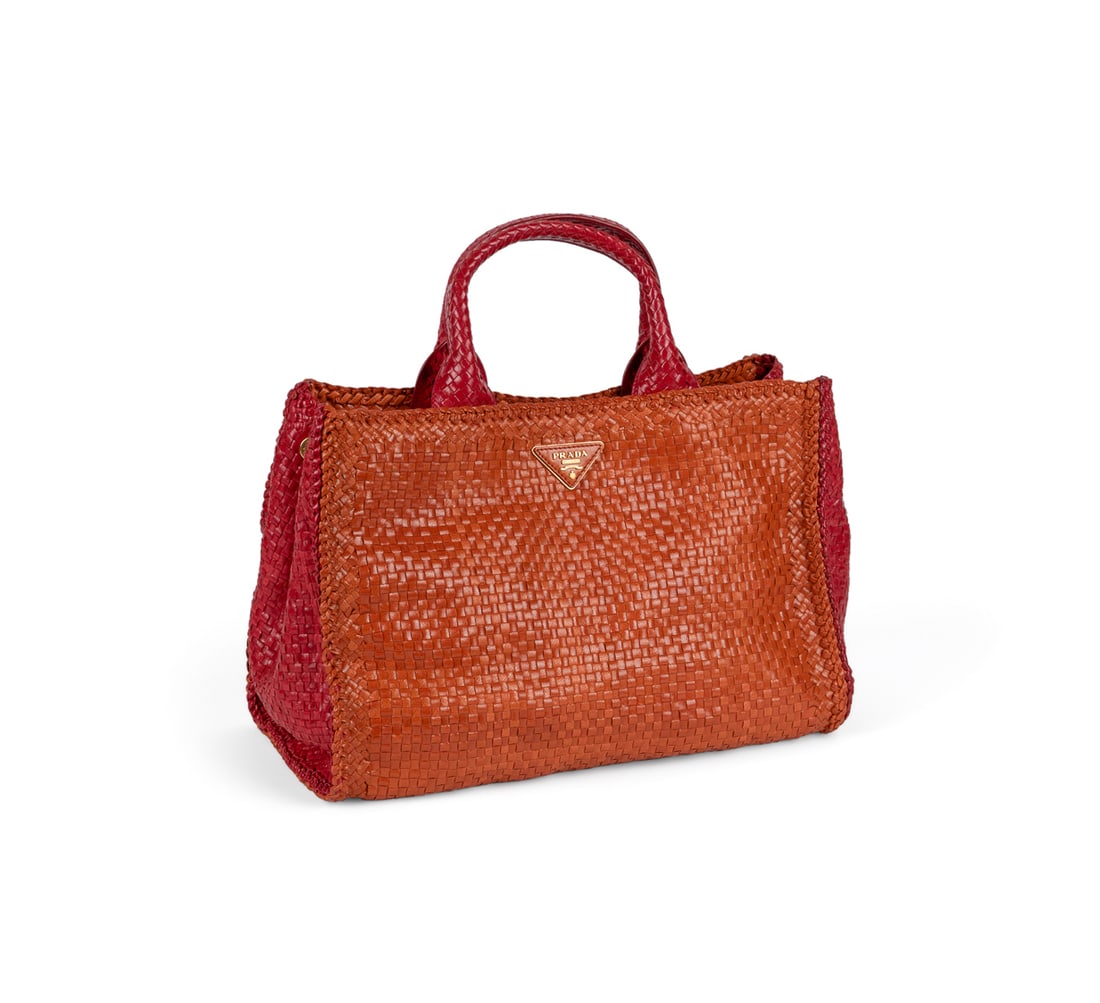 Prada Two Tone Madras Woven Leather Handbag: Prada (Italian, founded 1913). Orange and red woven leather Madras handbag with two top handles, removable crossbody strap, two tone leather, gold toned hardware, leather interior lining, and triangle