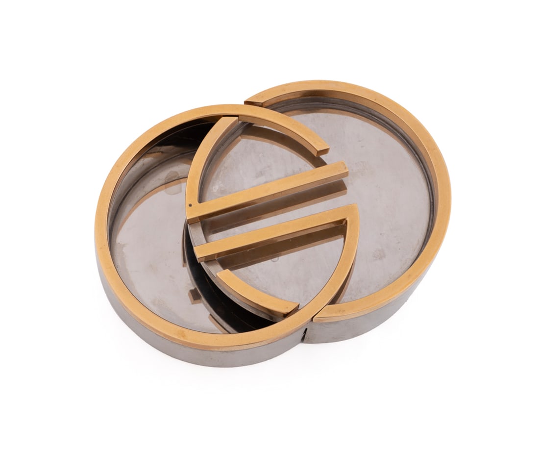 Gucci Interlocking Logo Ashtray, 1980s: Gucci (Italian, founded 1921), 1980s. Composed of two interlocking angled gilt metal and chrome "G" trays. Appropriately marked Approximate dimensions: Together: 2 1/4 x 8 1/4 x 6 in. (5.7 x 21 x 15.2
