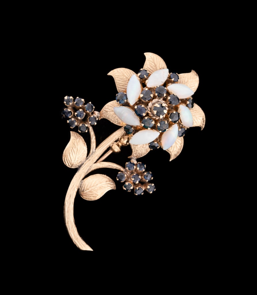 14K Yellow Gold, Opal and Topaz Flower Brooch: Textured yellow gold leaves and stem, featuring a central cluster of eight round cut blue topaz, surrounded by seven marquise cut cabochon opals, accented by seven round cut blue topaz, and two leaves