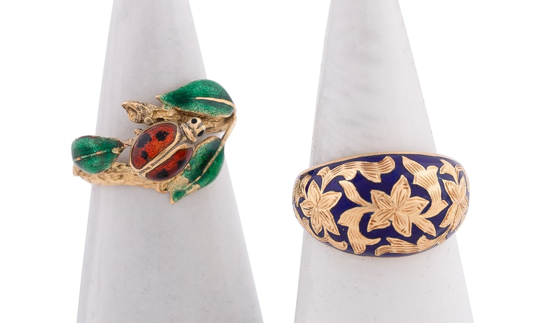 Two 18K Yellow Gold and Enamel Rings: One dome shaped ring displaying engraved yellow gold floral motif on blue enamel background, and one ring featuring enameled green leaves and red ladybug insect. Both stamped '18K'. Approximate dimens