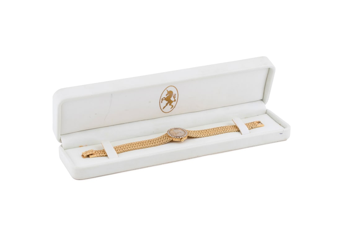 Piaget 18K Yellow Gold and Diamond Wristwatch: Oval case, Mother-of-Pearl face with four diamond dot indicators, round cut diamond set bezel, quartz movement, textured woven yellow gold bracelet with fold over clasp and signature 'P'. Serial no: 4