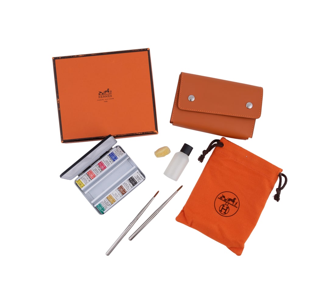 Hermes Watercolor Kit with Case: Hermes (French, founded 1837). Mini watercolor kit with original box, dust bag, orange leather case with snap button closures, a black metal tin, 1 water bottle, 8 watercolor bricks, 1 small sponge, a