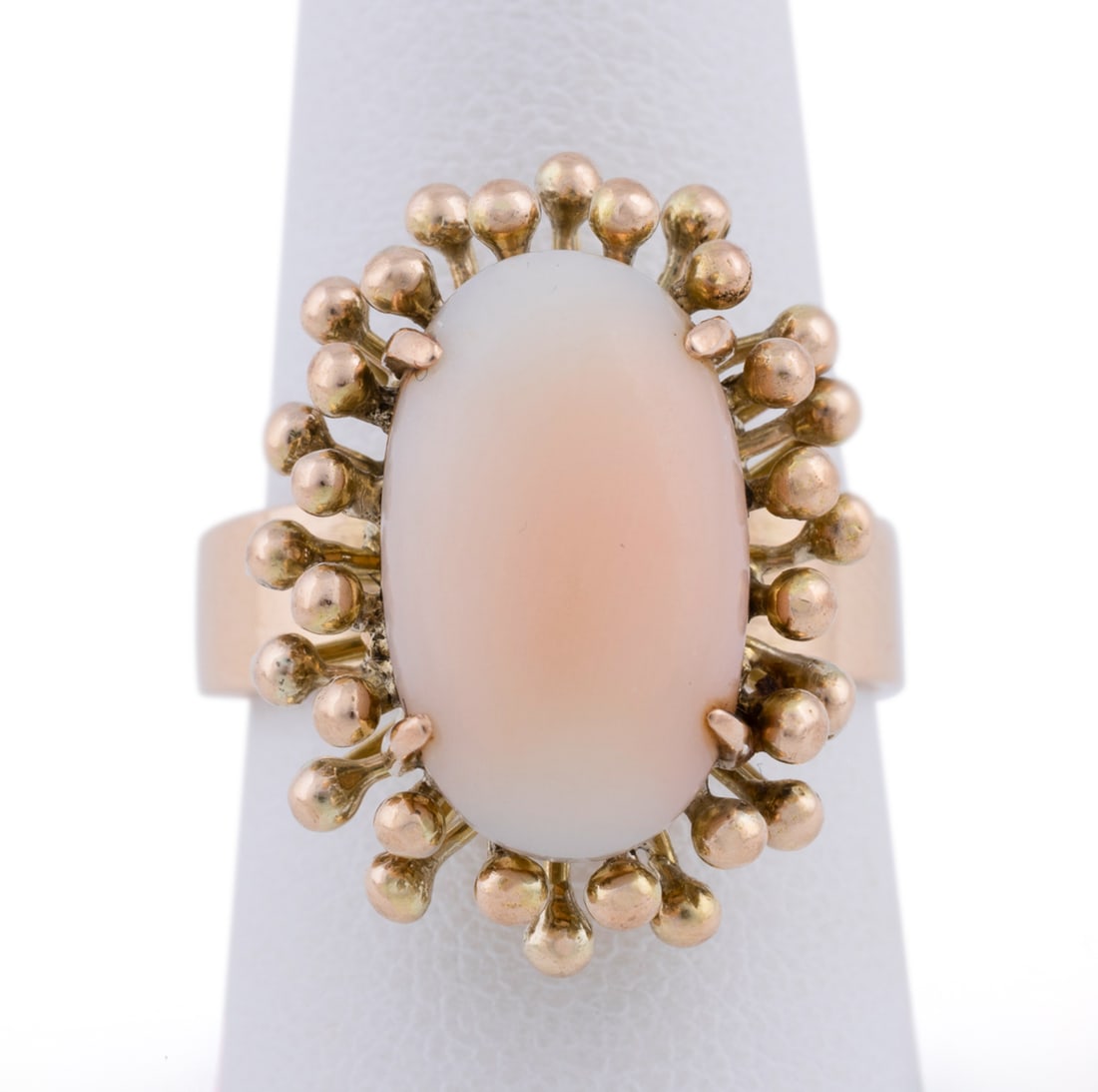 14K Yellow Gold and Coral Ring: Displaying an oval prong set cabochon coral within a raised yellow gold granulated bead surround. Stamped '585 14K'. Approximate dimensions: Ring size: 89.06 grams Note: Direct credit card payment
