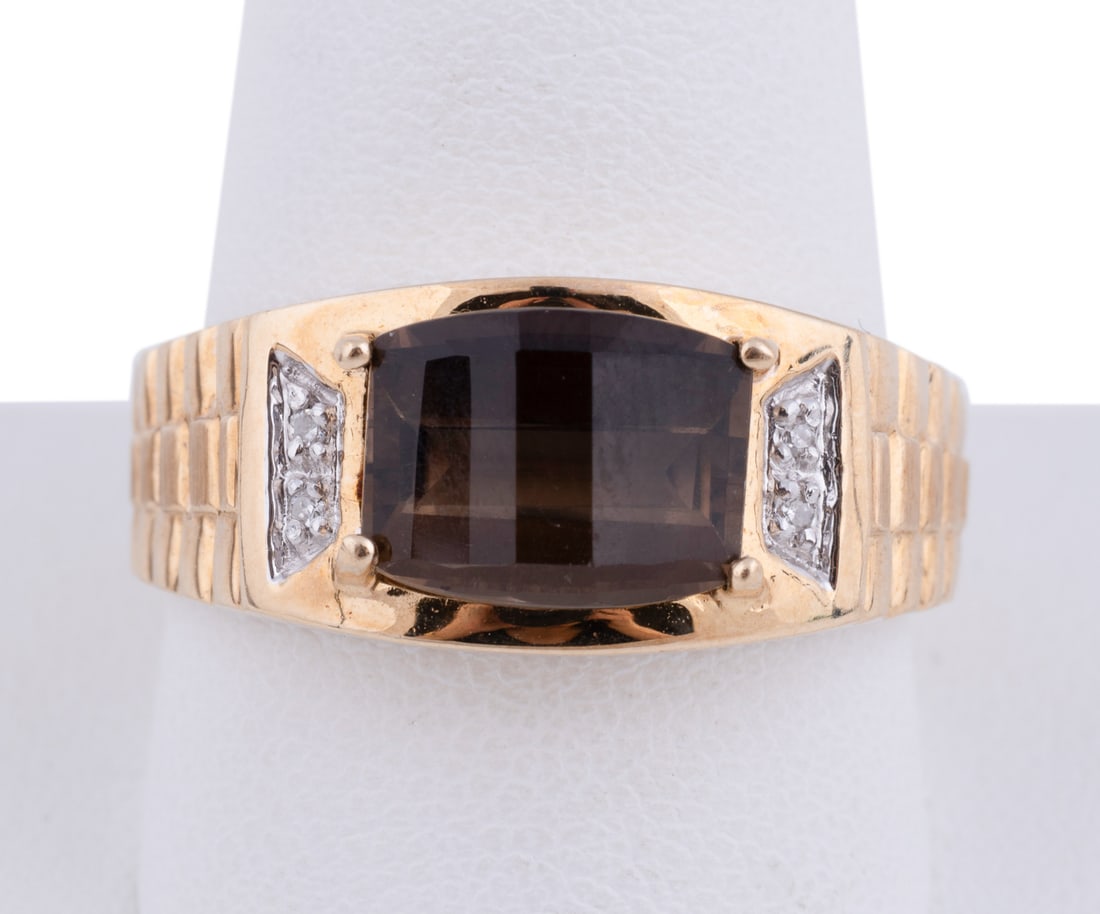 Smoky Quartz & Diamond 10k Yellow Gold Ring: Centering on a prong set modified rectangular cut smoky quartz weighing approximately 3.10 carats, framed on either side by two petite round cut diamonds pave set in white gold, yellow gold band with